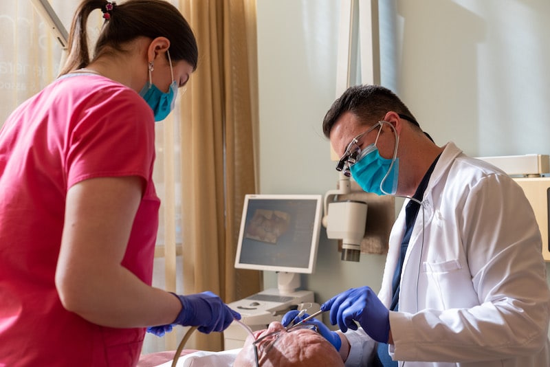 Dentist and Dental Assistant performing treatment on a patient at Kimberly Smiles